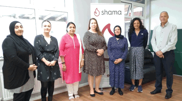 Elysia McCaffrey and Frank Hanson with members of the Shama Women's Centre